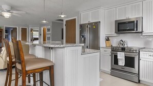 A kitchen with white cabinetry, a stainless steel refrigerator, a built-in microwave, and a double oven. - Waterfront-canal/w/Gulf view-pets welcome-private dock for a fee. (Hudson)
