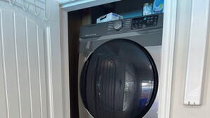 A compact, two-door laundry room with a Samsung washer and dryer. - Swimming pool, Family friendly home! (Penticton)