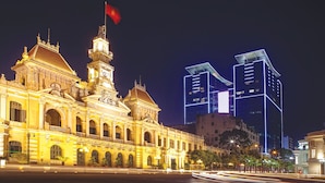 A historic building with ornate architecture and a clock tower, adjacent to modern high-rise buildings. - RedDoorz @ Cong Hoa Street (Ho Chi Minh City)