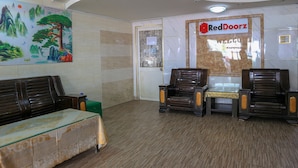 A waiting area with a reception desk, a mural, and a RedDoorz sign. - RedDoorz @ Cong Hoa Street (Ho Chi Minh City)