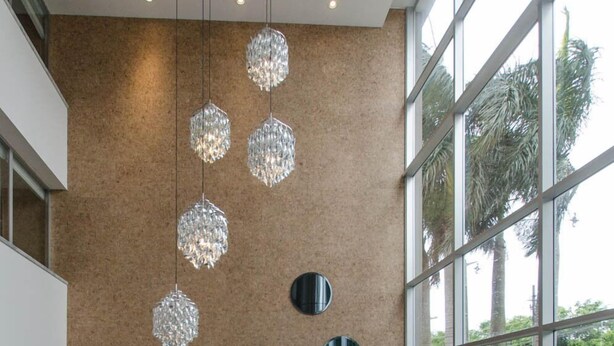Un saló modern amb un sofà modular, una taula de centre de vidre i llums pendants decoratives de cristall.