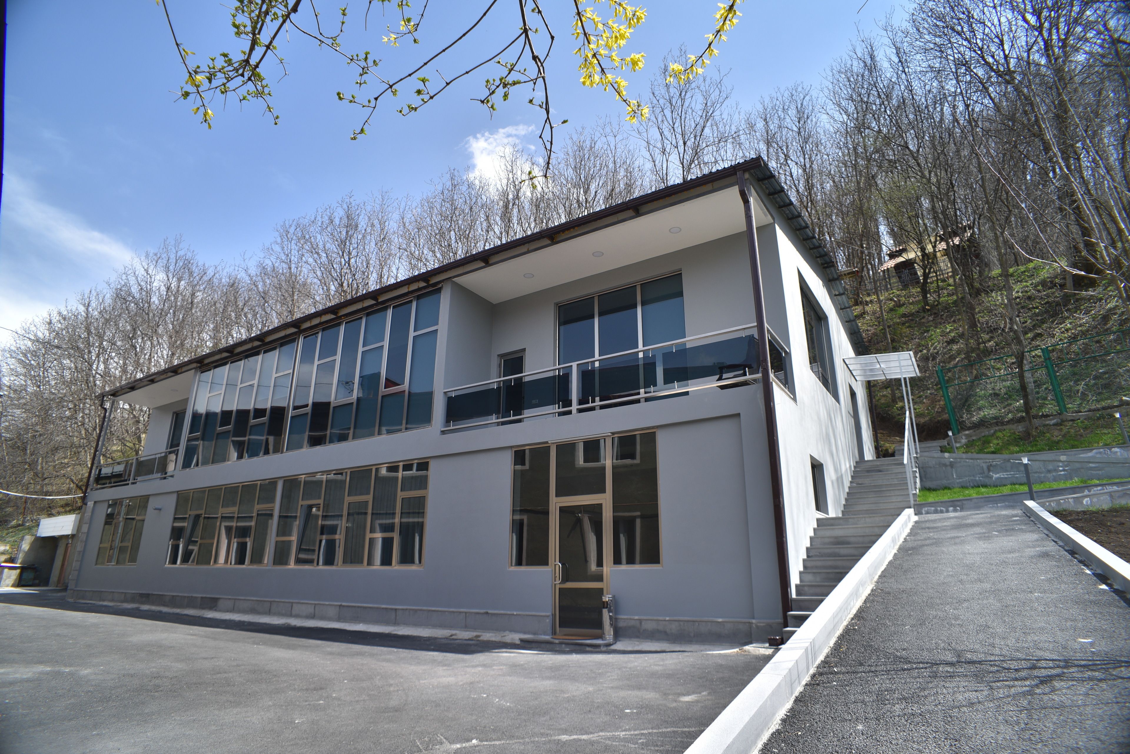 Un edificio moderno de dos pisos con ventanas amplias y un balcón.