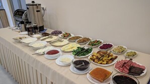 Mesa de buffet com diversos pratos e acompanhamentos.