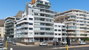A multi-story building with balconies, a street in front, and cars parked along the road. - Saratoga 304 (Cape Town)