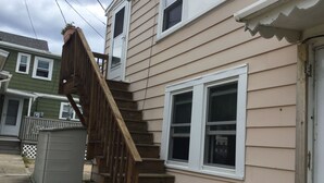 Un immeuble résidentiel avec un escalier en bois menant à une fenêtre du deuxième étage.