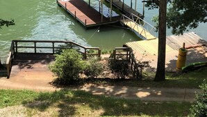 Une jetée s’avançant dans un lac, avec un espace de repos abrité et une passerelle en bois menant à cet espace.