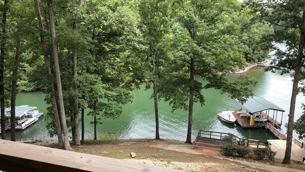 Une vue d’un lac où sont amarrés des bateaux, le tout entouré d’arbres.