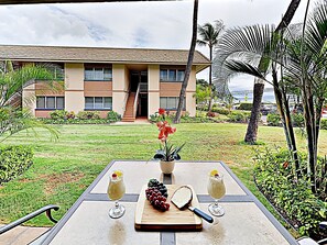 A table set outdoors with a view of a building and palm trees.