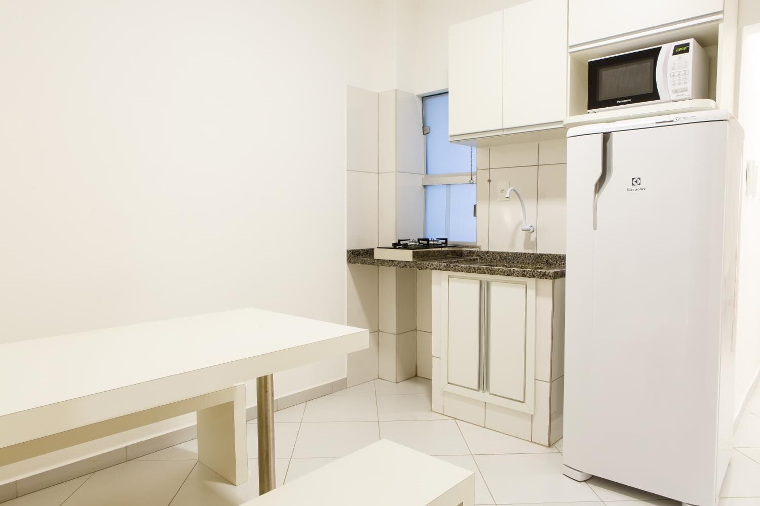 A small kitchenette with a microwave, sink, and stove.