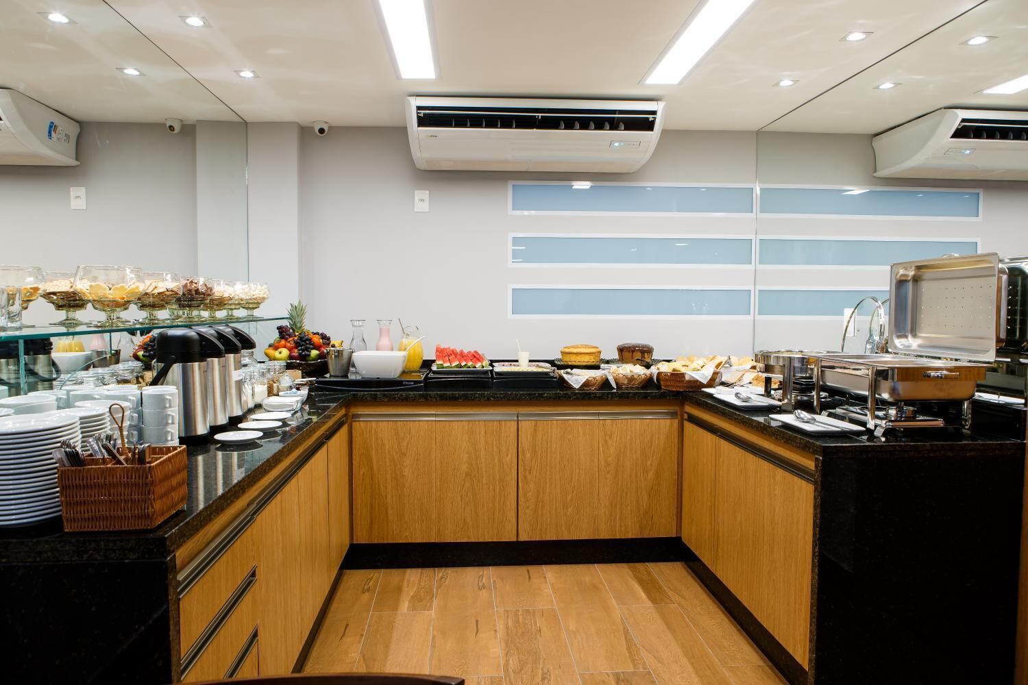 A modern kitchen with a buffet setup, including various food items and utensils.