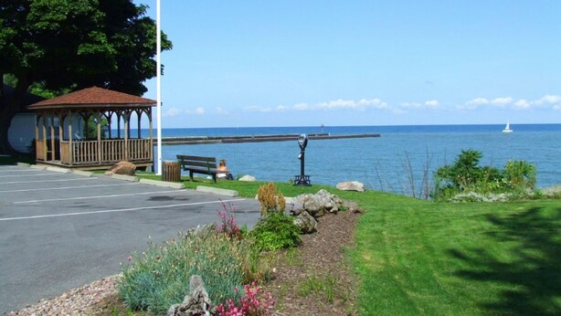 Un belvédère avec un banc, un parking et une vue sur la mer.