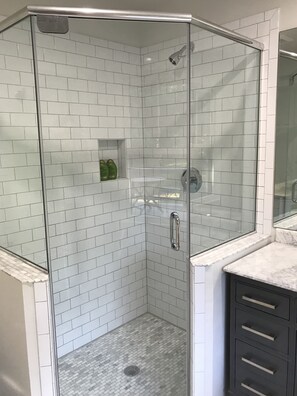 Een bad/douchecombinatie, een haardroger, handdoeken, zeep