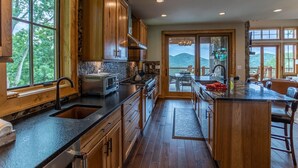 A spacious kitchen with wooden cabinets, a large island, and a view of the outdoors.