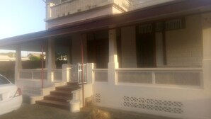 A two-story house with a porch, a staircase, and a car parked in front. - Robert's Guesthouse in Port of Spain.
In the Heart of Carnival 2026 (St Clair)