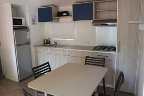 Een koelkast met diepvriezer, een microgolfoven, een kookplaat