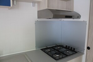 Een koelkast met diepvriezer, een microgolfoven, een kookplaat