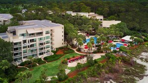 Ein Resort mit mehreren Gebäuden, einem Swimmingpool und üppiger Vegetation.