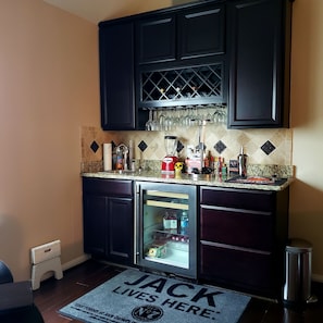 Guests can enjoy a fully equipped kitchen with a wine cooler, refrigerator, and various kitchen essentials.