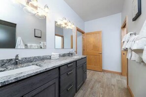 A bathroom with two sinks, a large mirror, and a wooden door. - Waterfront Family Retreat on Green Bay w/ kayaks (Luxemburg)