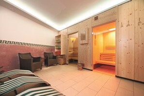 Ein Sauna-Raum mit Holzwänden, einer Sitzbank und einer weiteren Sitzbank mit Streifenbezug.