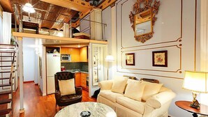 A spacious living area with a high ceiling, a sofa, a coffee table, and a dining table.