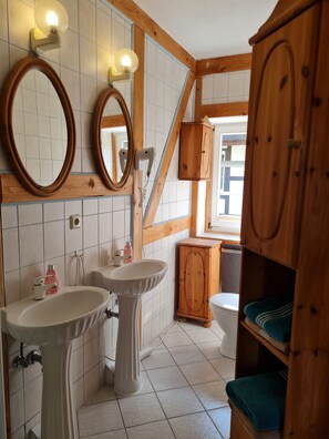 A bathroom with two sinks, wooden cabinets, and a mirror. - E - Uns Schün, Germany (Middelhagen)
