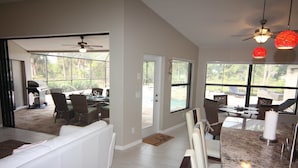 A spacious living area with a white sofa, dining table with chairs, and a kitchen counter. - Secret Escape (Rotonda West)