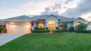 A two-story house with a well-maintained lawn, a garage, and a front door with a small porch. - Amazing Lagoon (Rotonda West)