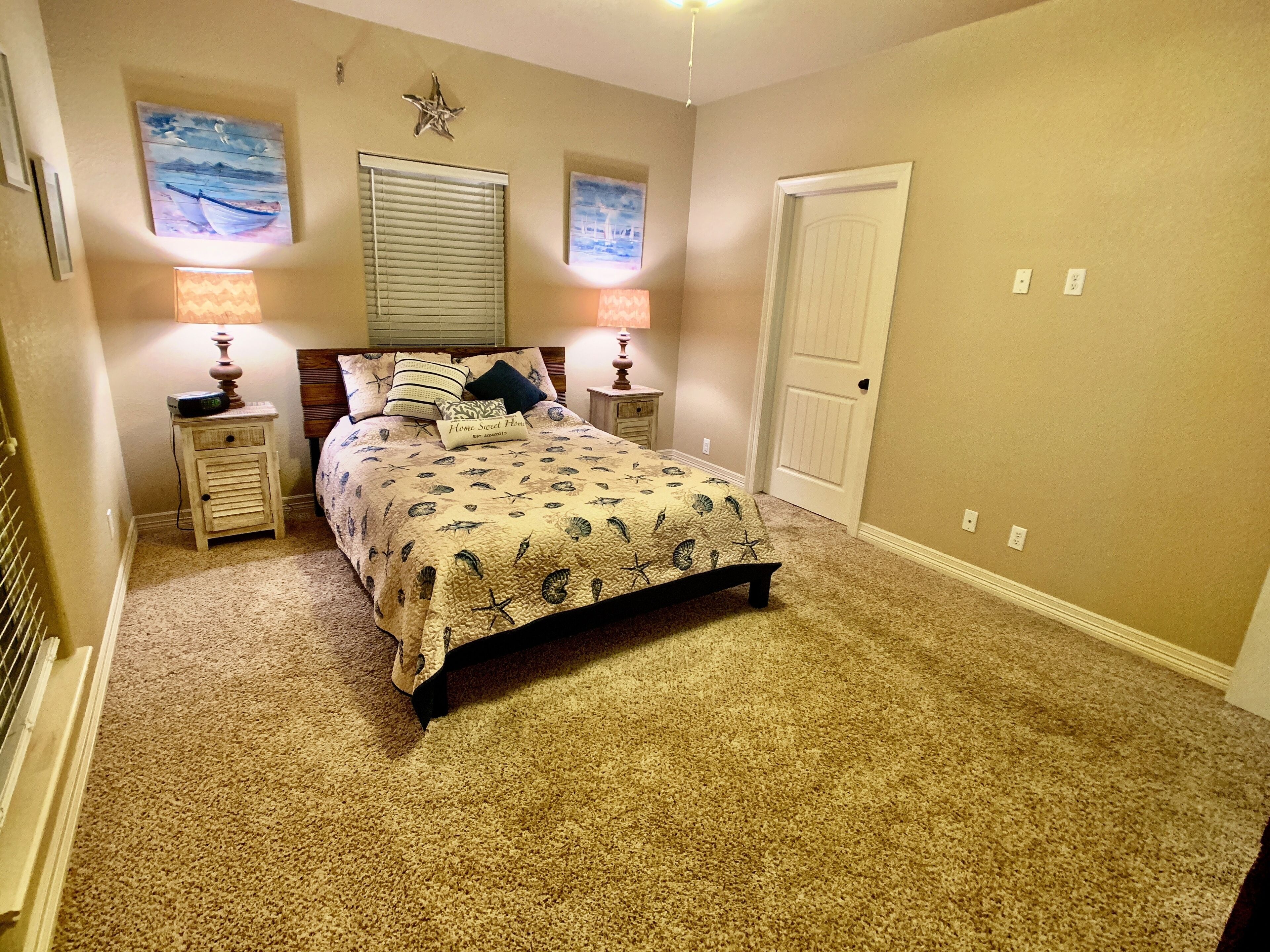 A bedroom with a bed, two nightstands, a star decoration, and two wall-mounted lamps.