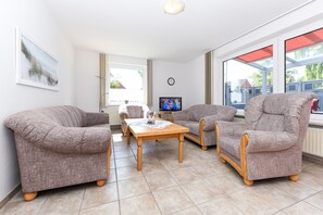 A living room with a sofa set, a coffee table, and a television.