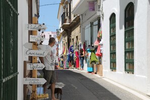 A narrow street with a signpost indicating directions to local attractions.