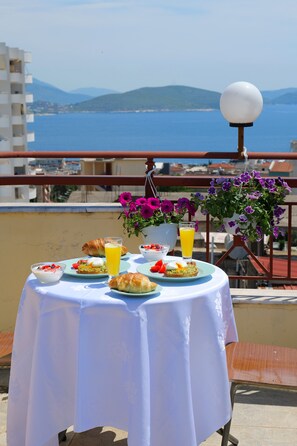 A table set with breakfast items on a balcony overlooking the sea. - Eden Hotel (Sarandë)