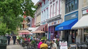 An outdoor cafe with outdoor seating, a Chase bank, and a sign for a restaurant. - Historic Cottage in the Heart of the Village (Granville)