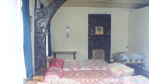 Un dormitorio con una cama grande, una mesita y una silla.