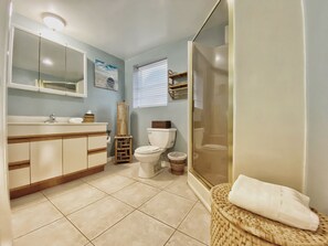 A bathroom with a sink, toilet, and shower area. - BeachTrail Lodging (Indian Rocks Beach)