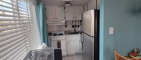 A kitchen with white cabinets, a black countertop, and a sign that reads "COAST".