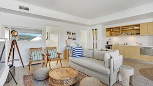 A modern living room with a sofa, chairs, a coffee table, and a view of the outdoors. - Sunchaser - Iluka - Palm Beach (Palm Beach)