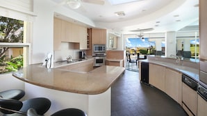 Una cocina moderna con una isla central, electrodomésticos integrados y vistas al exterior.