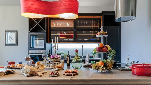 Una encimera de cocina con diversos alimentos y una exposición de frutas.