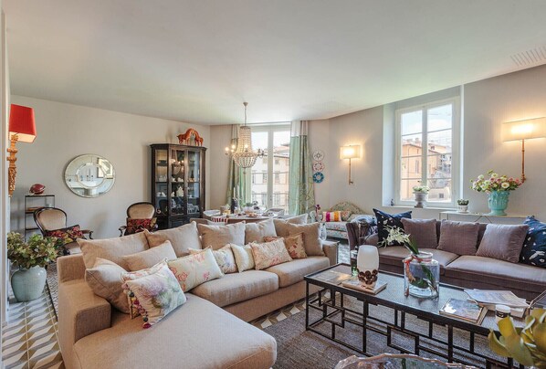 A cozy living room with a sectional sofa, a coffee table, and a cabinet with glass doors.