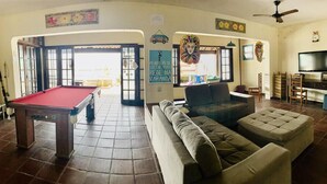 A living room with a pool table, a sofa, and a television. - Pousada Tartaruga (Rio das Ostras)