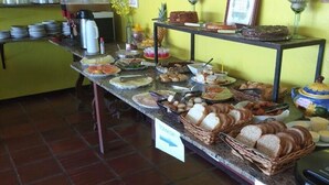 A buffet with various food items and a coffee station. - Pousada Tartaruga (Rio das Ostras)