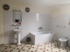Un baño con lavamanos, bañera y bidé.