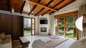 Een moderne slaapkamer met een groot bed, een bank, een salontafel en een televisie.
