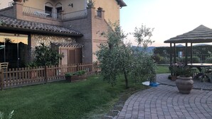 A courtyard with a brick pathway, a wooden fence, and a gazebo. - Cottage  (Orciano pisano)