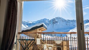 Ein Zimmer mit einem großen Fenster mit Blick auf eine verschneite Berglandschaft.