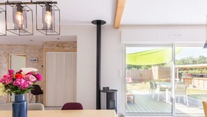 Ein Essbereich mit Tisch für zwei Personen, einer Blumenvase und Blick auf die Terrasses.
