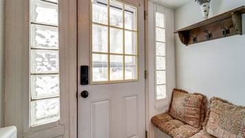 A white door with frosted glass panels and a bench with patterned cushions.