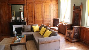 A living room with a sofa, coffee table, and wooden paneling. - Authentic Norman house between countryside and sea (Lindebeuf)