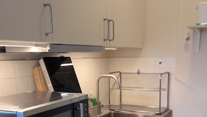 Una cucina moderna con forno a microonde, lavastoviglie e lavello in acciaio inossidabile.